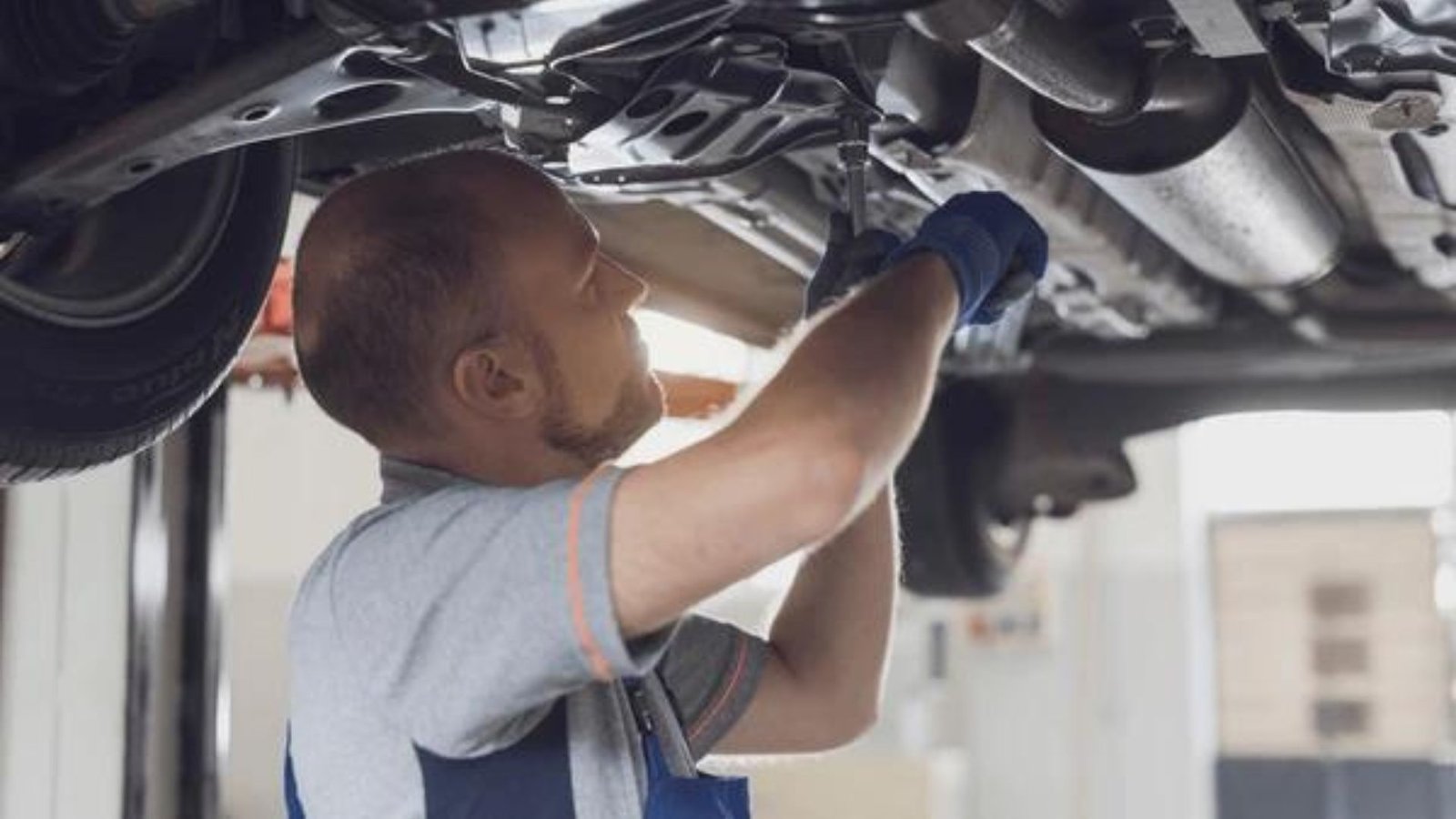 A Man Repairing an Exhaust Showing the Top 5 Signs Your Exhaust Needs Repair